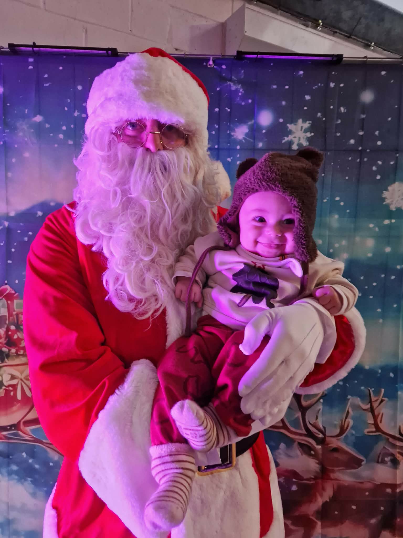 Le Père Noël portant un enfant émerveillé lors d'une visite